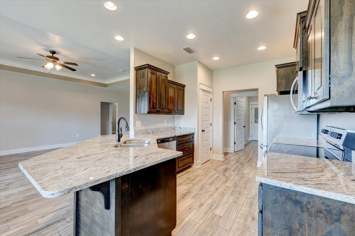 3956 Painter Branch Road Crestview, FL 32539 - Photo 9 of 28 a kitchen with stainless steel appliances granite countertop a sink dishwasher and a stove with wooden floor