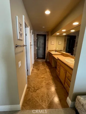 a large bathroom with a sink and a refrigerator