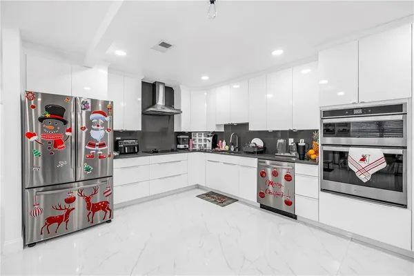 a large white kitchen with lots of appliances