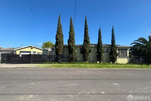 a view of a house with a yard and palm trees