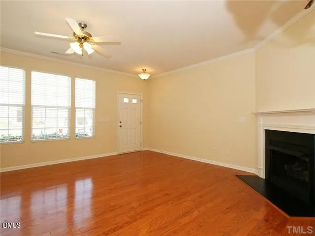 a view of an empty room with a window and a ceiling fan