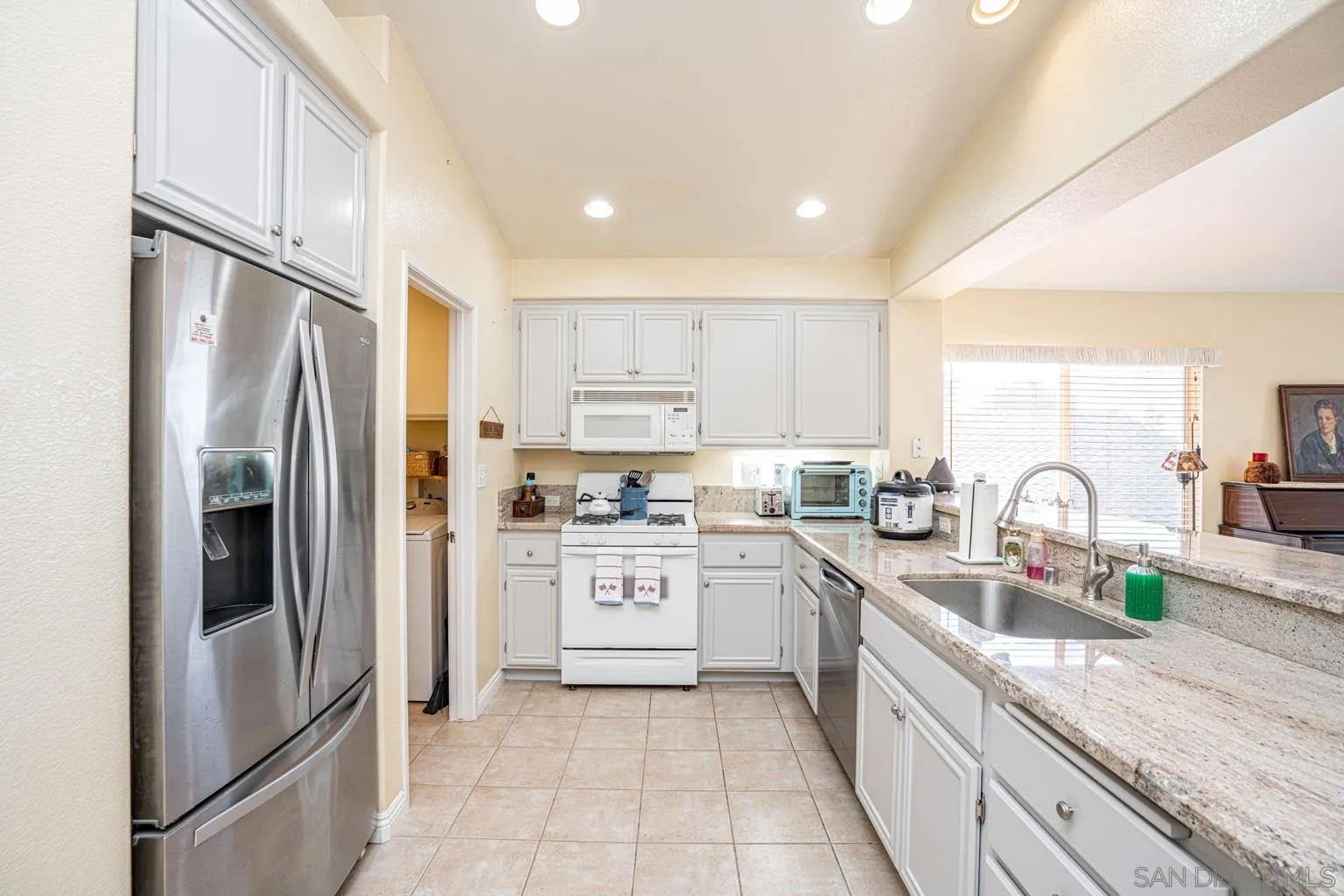 2602 Columbine Road Alpine, CA 91901 - Photo 9 of 38 a kitchen with stainless steel appliances granite countertop a refrigerator sink and white cabinets