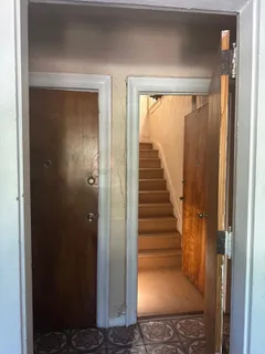 a view of a hallway with wooden floor and entryway