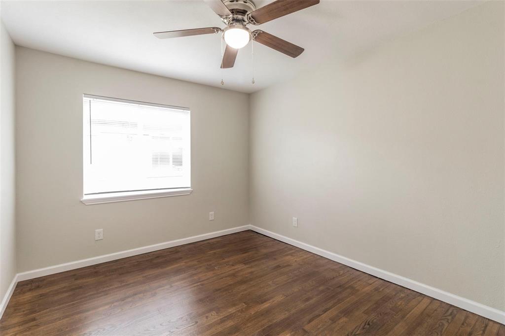 4714 Old Benbrook Road Fort Worth, TX 76116 - Photo 8 of 15 an empty room with wooden floor fan and windows