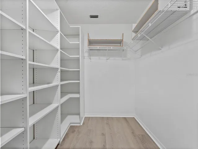 a view of walk in closet with empty racks