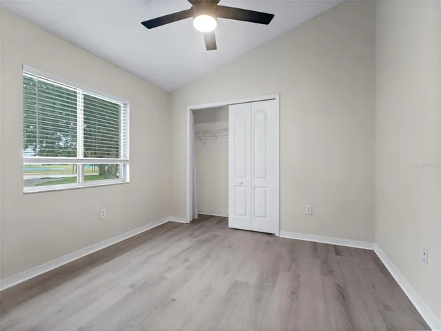 an empty room with a window and a ceiling fan