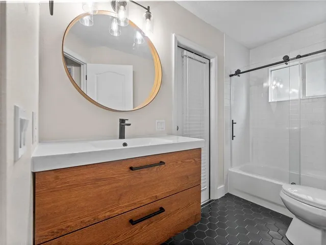 a bathroom with a sink a mirror a toilet and a mirror