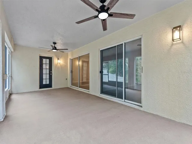 an empty room with fan and windows