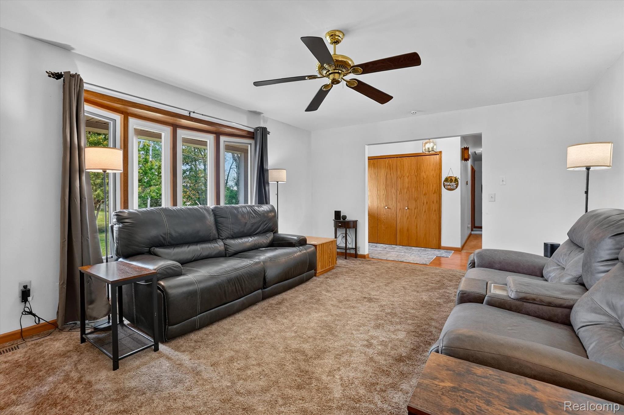 6895 Stow Road Fowlerville, MI 48836 - Photo 6 of 45 Living area featuring a bay window, ceiling fan, and carpeted flooring