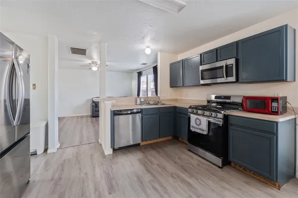 a kitchen with stainless steel appliances granite countertop a stove a sink and a refrigerator
