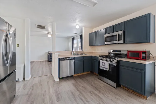 a kitchen with stainless steel appliances granite countertop a stove a sink and a refrigerator