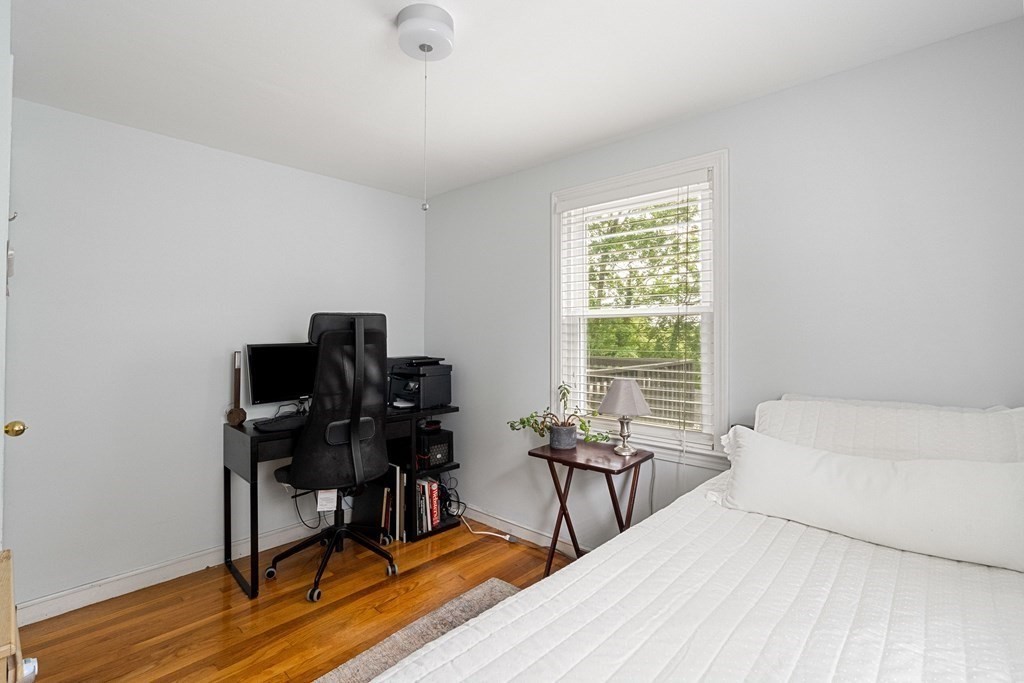 63 Hallron Street Boston, MA 02136 - Photo 23 of 32 a bedroom with a bed a desk and chair with wooden floor