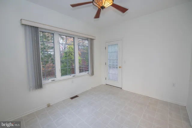 an empty room with a window and ceiling fan