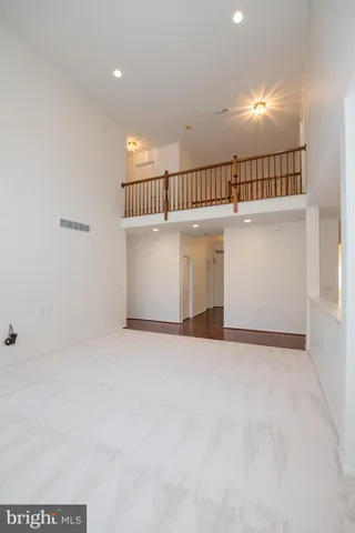 a view of an empty room with wooden floor and closet