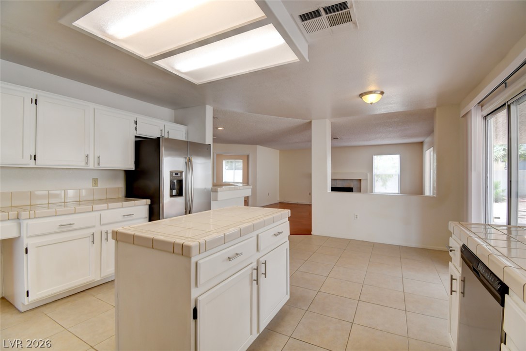 5 Tarryall Terrace Henderson, NV 89074 - Photo 23 of 44 A well-lit kitchen with a tiled island, sleek stainless steel appliances, and ample cabinet space.