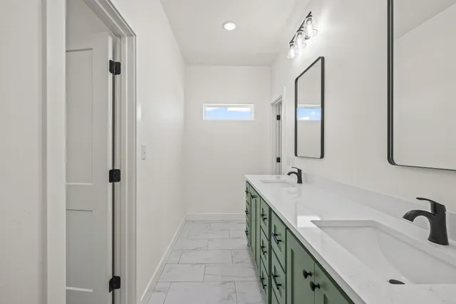 a spacious bathroom with a double vanity sink a mirror and shower