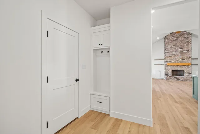 a view of a hallway with wooden floor and closet
