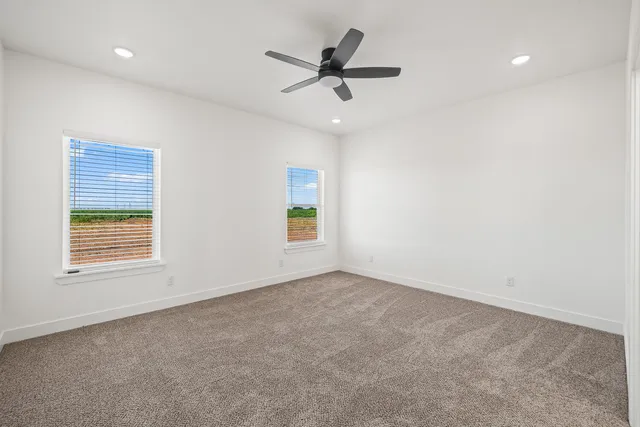 an empty room with a window and a ceiling fan
