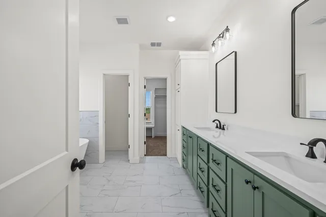 a spacious bathroom with a double vanity sink a mirror and a shower