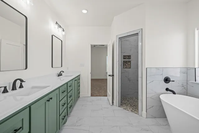 a bathroom with a double vanity sink a mirror and a bathtub