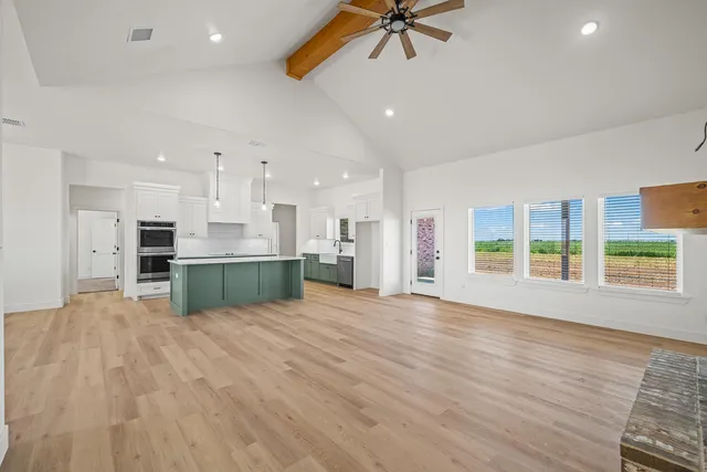 a view of an empty room with a kitchen