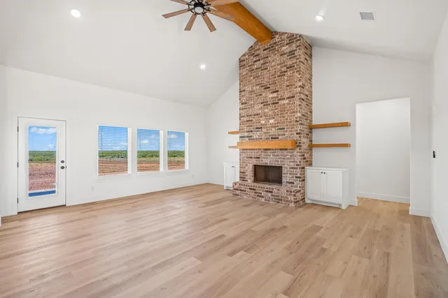 an empty room with windows and fireplace