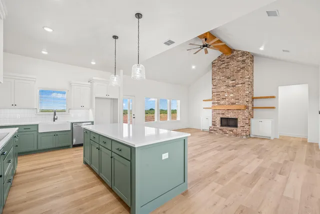 a kitchen with stainless steel appliances granite countertop a sink a stove and a wooden floor