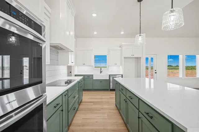 a large kitchen with stainless steel appliances lots of counter space and a sink