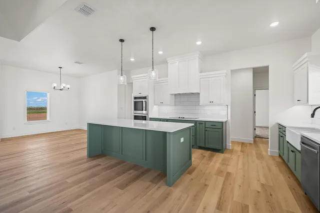 a kitchen with stainless steel appliances granite countertop a sink a stove and a wooden floors