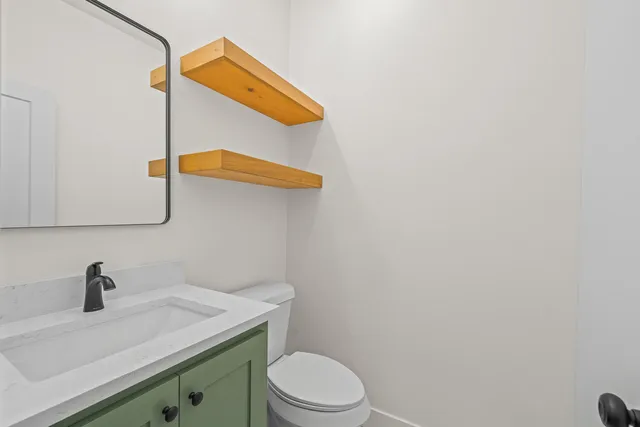 a bathroom with a sink a toilet and mirror