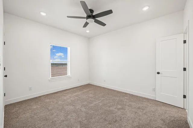 an empty room with a window and a fan