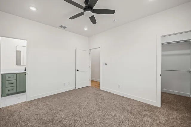an empty room with closet and windows