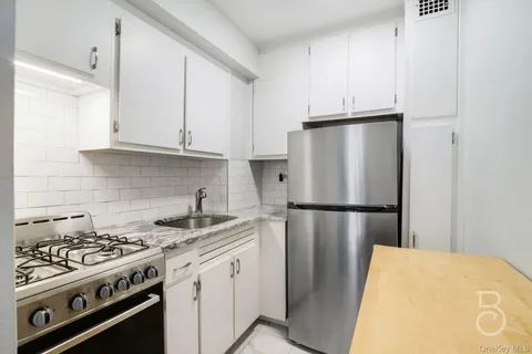 a white refrigerator freezer and a stove sitting inside of a kitchen