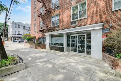 a view of a building with a garden in the background