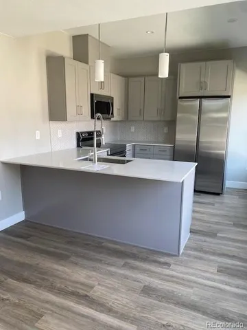 a kitchen with stainless steel appliances a sink refrigerator and microwave