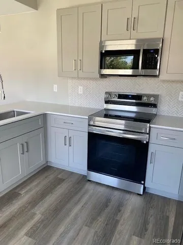 a kitchen with stainless steel appliances granite countertop a stove a microwave and oven