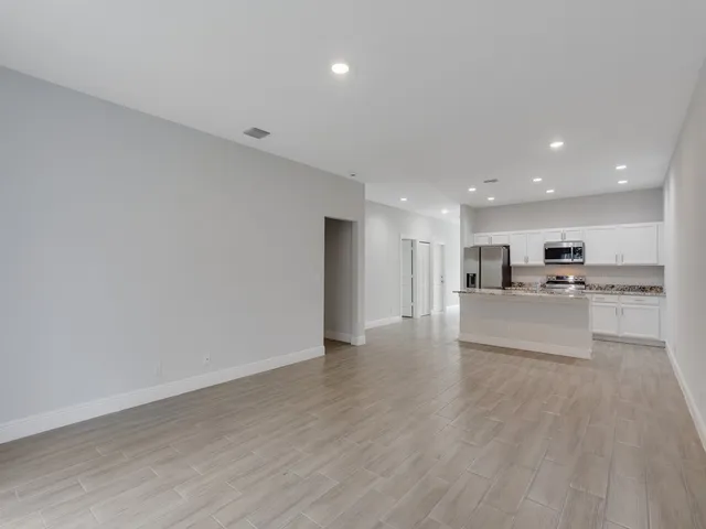 a view of kitchen with kitchen island and stainless steel appliances