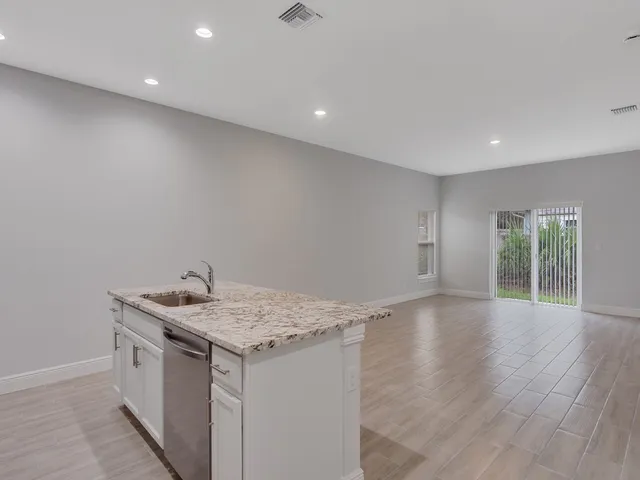 a kitchen with a sink and wooden floor