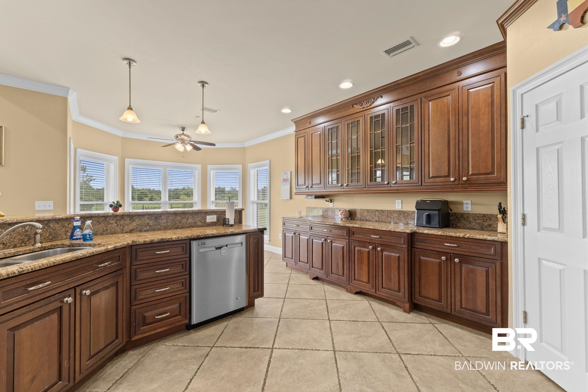 9790 Stucki Road Elberta, AL 36530 - Photo 35 of 72 Kitchen with stainless steel dishwasher, a sink, ornamental molding, a ceiling fan, and light tile patterned floors