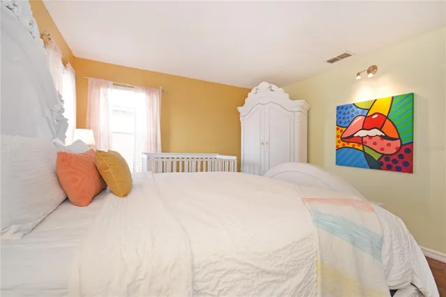 a bedroom with a bed and painting on the wall