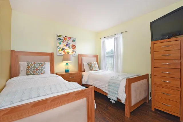 a bedroom with two bed and a flat screen tv