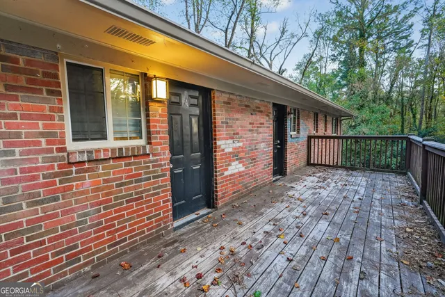 a view of a brick house with wooden floor and fence