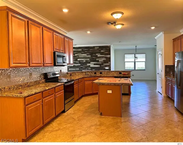 a large kitchen with stainless steel appliances granite countertop a stove a sink dishwasher and a refrigerator