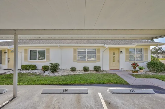 a front view of a house with a yard and potted plants