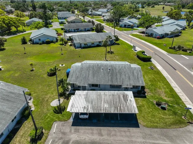 an aerial view of a house with a garden and lake view