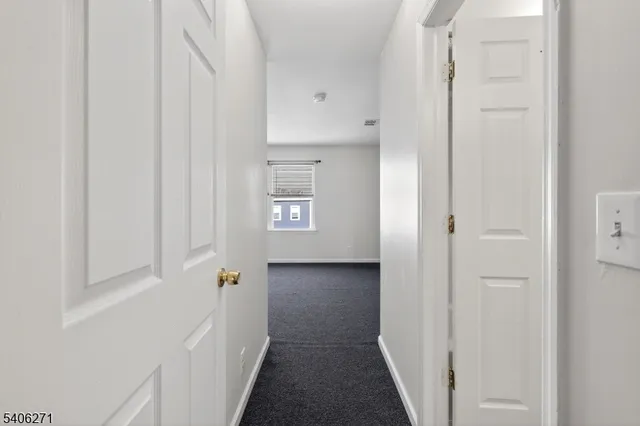 a view of a hallway with white doors