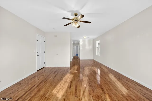 a view of empty room with wooden floor
