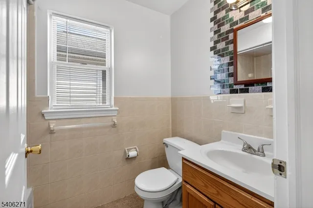 a bathroom with a granite countertop toilet a sink and a mirror