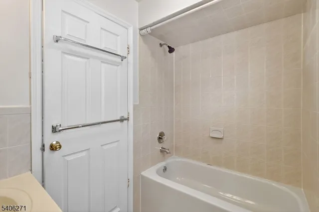 a white bath tub with shower