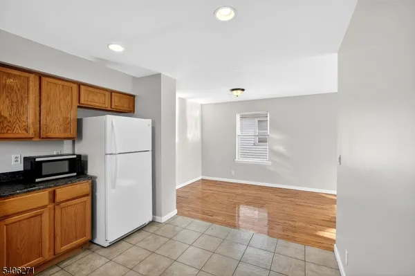 a view of kitchen with cabinets and refrigerator